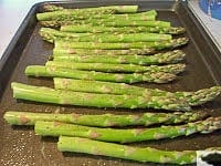 raw asparagus on a baking sheet
