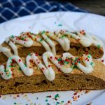 Two biscotti on a white plate with blue napkin in background