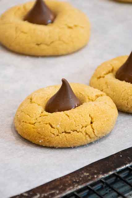 Peanut butter kisses on cookie sheet.