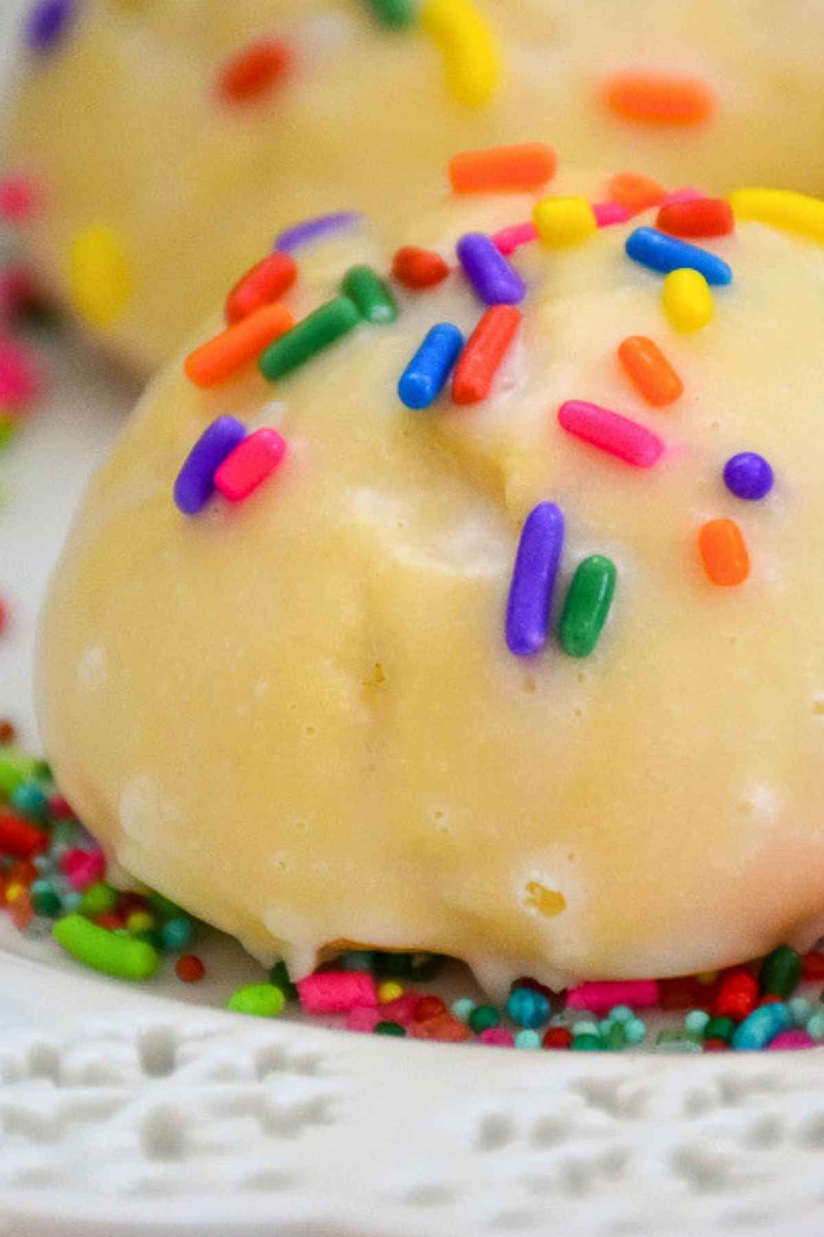 Upclose image of a glazed Italian Christmas Cookie with colorful sprinkles.