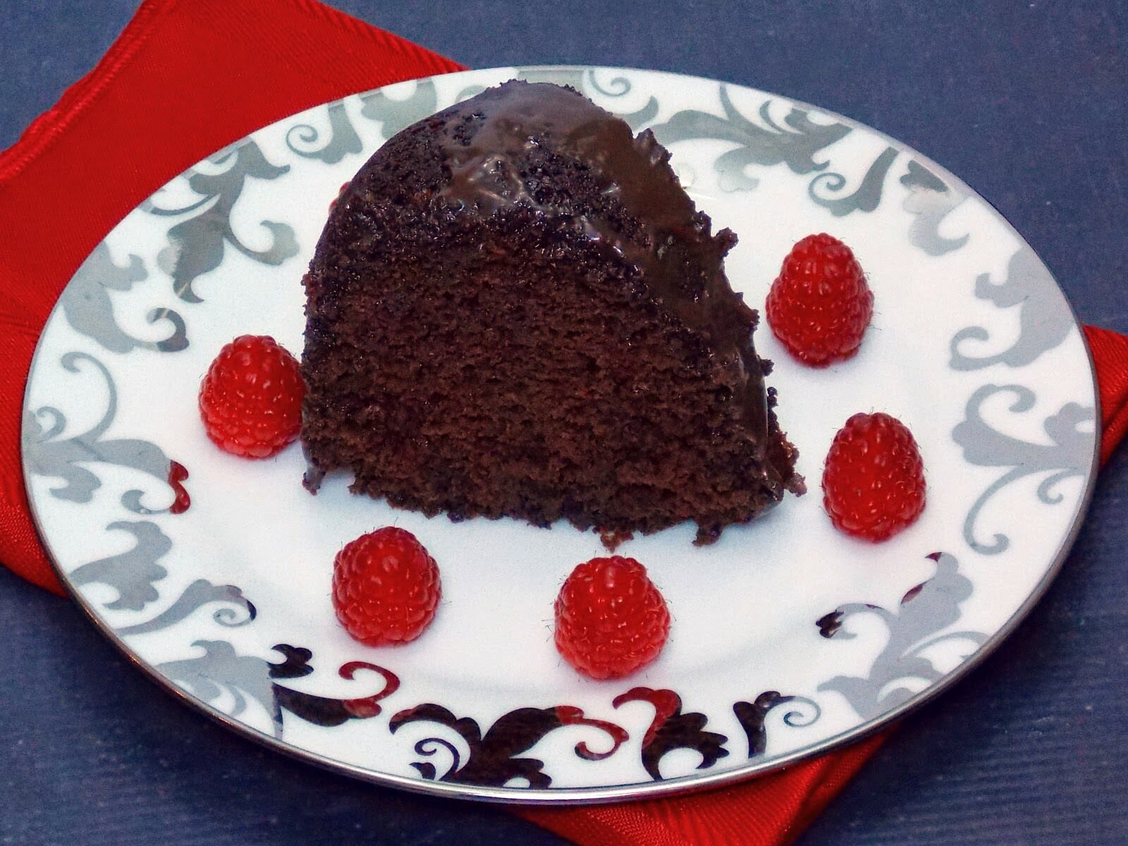 A slice of chocolate kahlua bundt cake on a white plate with silver trim.