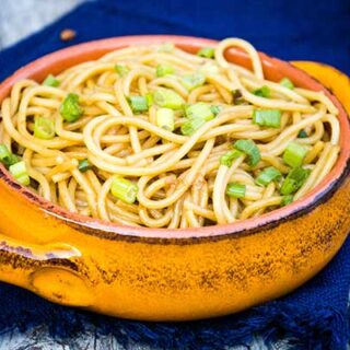 Garlic Scallion Noodles in an orange bowl with a blue napkin