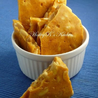 Pieces of Sweet and Spicy Chipotle Peanut Brittle in a white bowl.