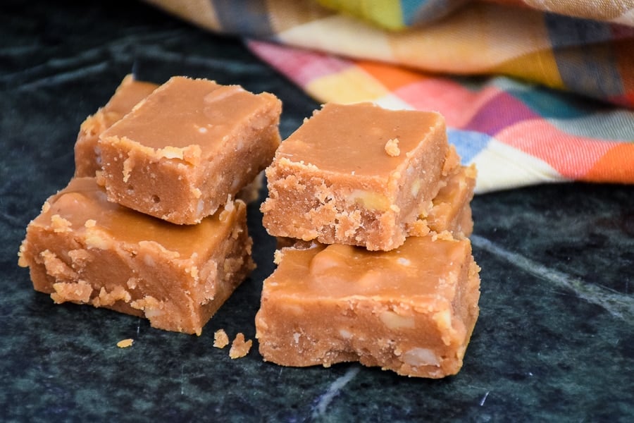 Four pieced of brown sugar fudge on a green marble countertop.