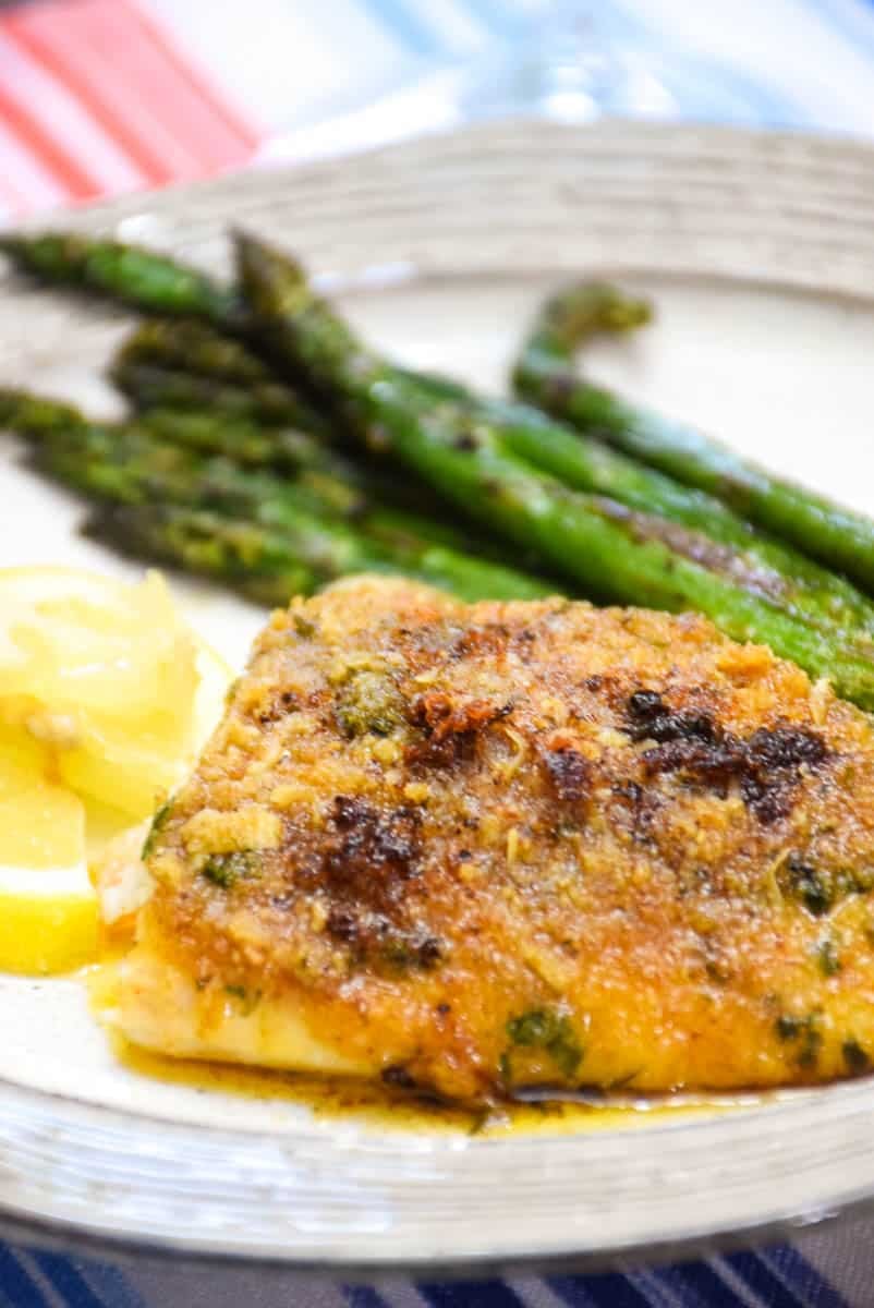 Baked Red Snapper with Garlic and a side of asparagus with lemon wedges.