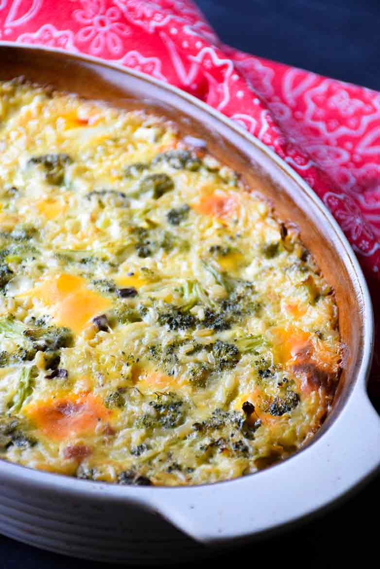 Baked easy Broccoli Rice and Cheese Casserole in a casserole dish with a red and white napkin to the right of the dish.