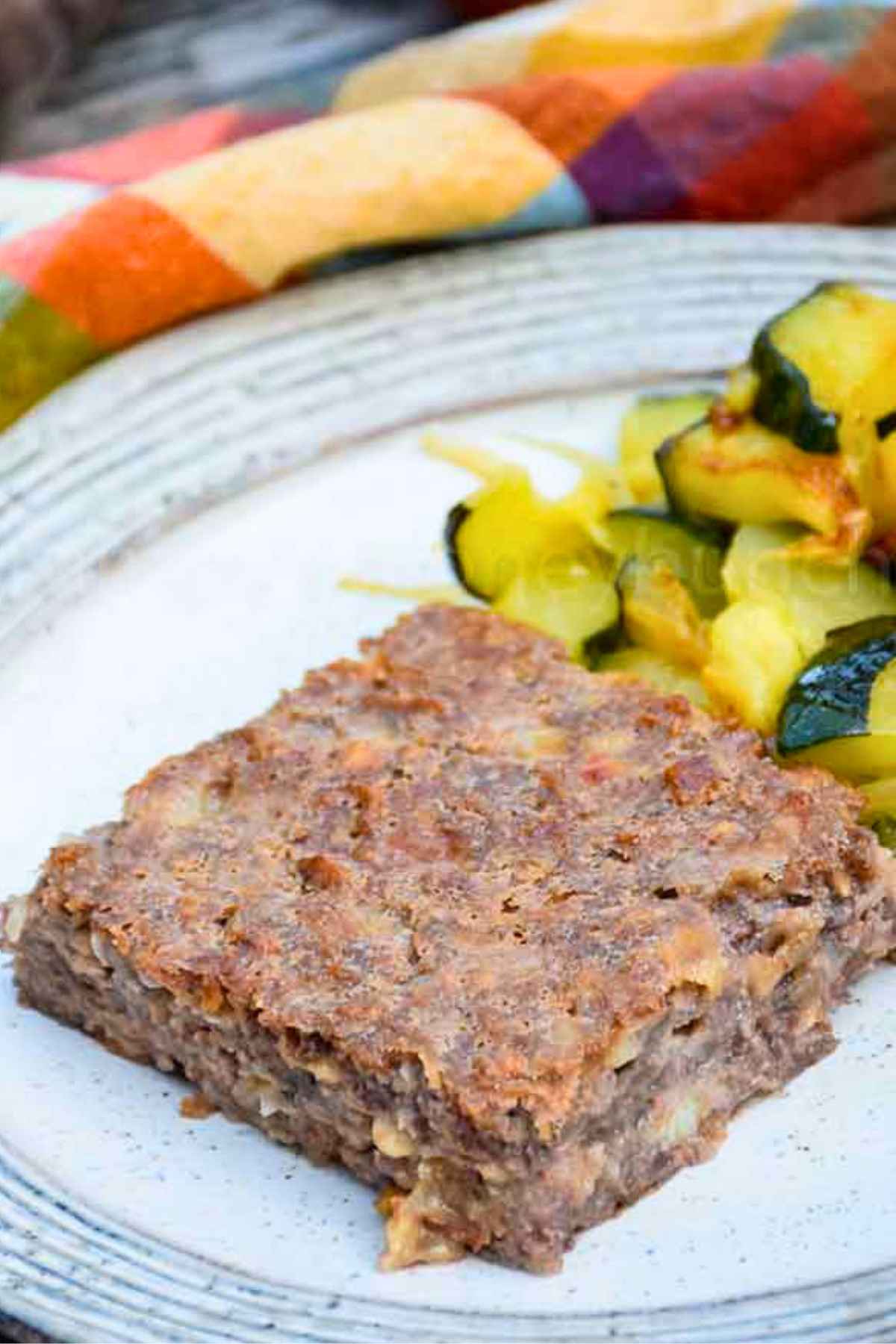 Upclose image of Special K Loaf on a plate with a side of sauteed zucchini