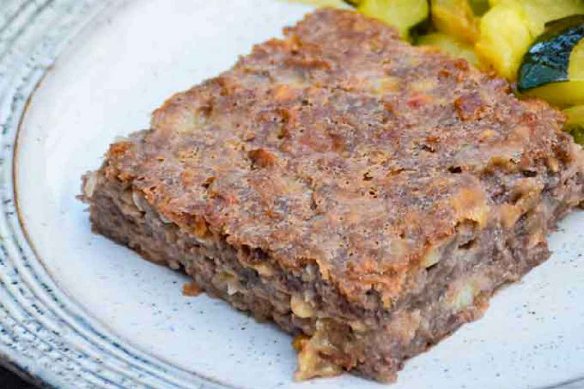 Upclose image of a slice of vegetarian loaf on a cream colored plate.