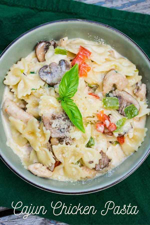 Cajun Chicken Pasta in a sage green bowl with a dark green napkin