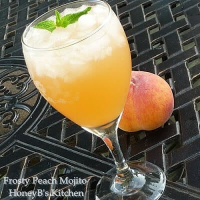 A clear glass filled with peach mojito garnished with mint.