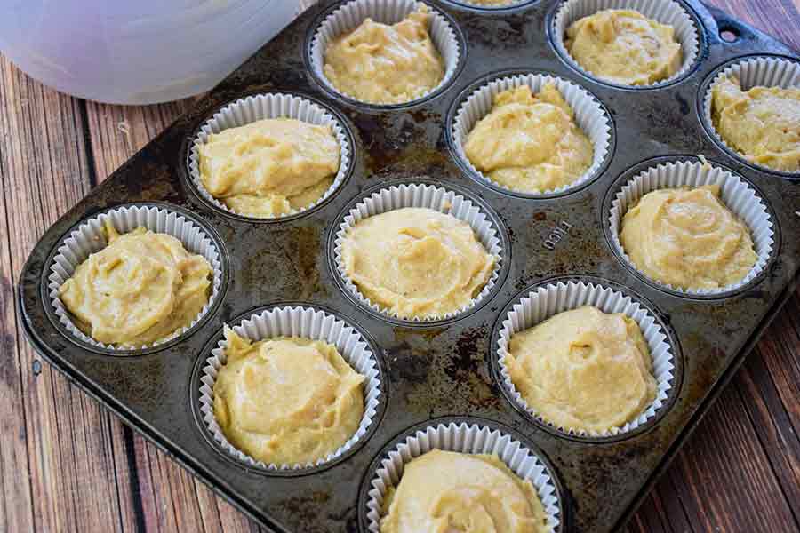 muffin batter in a muffin pan with paper liners