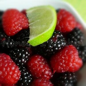 Upclose image of blackberries, raspberries, and lime slice.