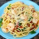 Weight Watcher's Garlic Shrimp Pasta with spinach and sun-dried tomatoes in a blue ceramic bowl.