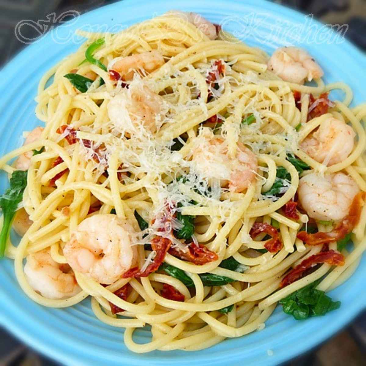 Weight Watcher's Garlic Shrimp Pasta with spinach and sun-dried tomatoes in a blue ceramic bowl.