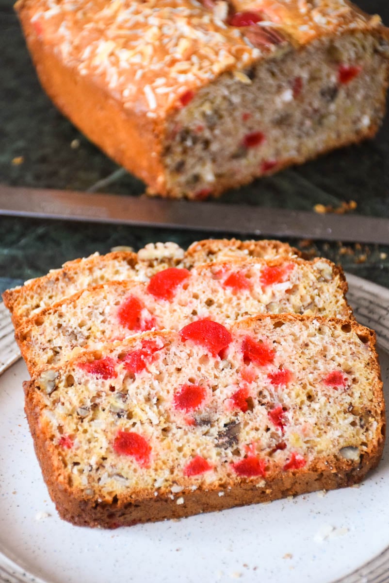 Coconut Cherry Banana Pecan Bread that has been cut with 3 slices on a plate.