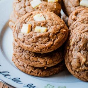 A festive holiday plate with stacks of chocolate peppermint bark cookies.