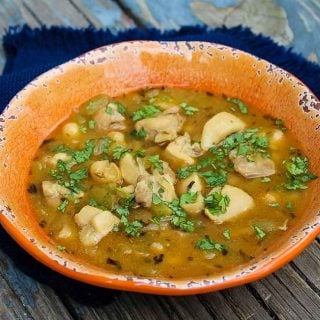 Horizontal image of chili recipe in a orange bowl with blue napkin