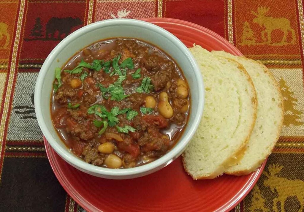 Venison White Bean Chili overhead shot with two slices of white bread on the right hand side