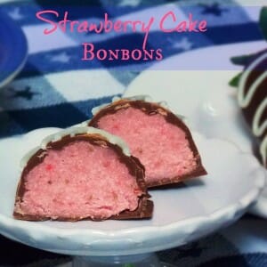 A close-up of Strawberry Cake Balls cut in half to show the soft pink cake center and chocolate coating.