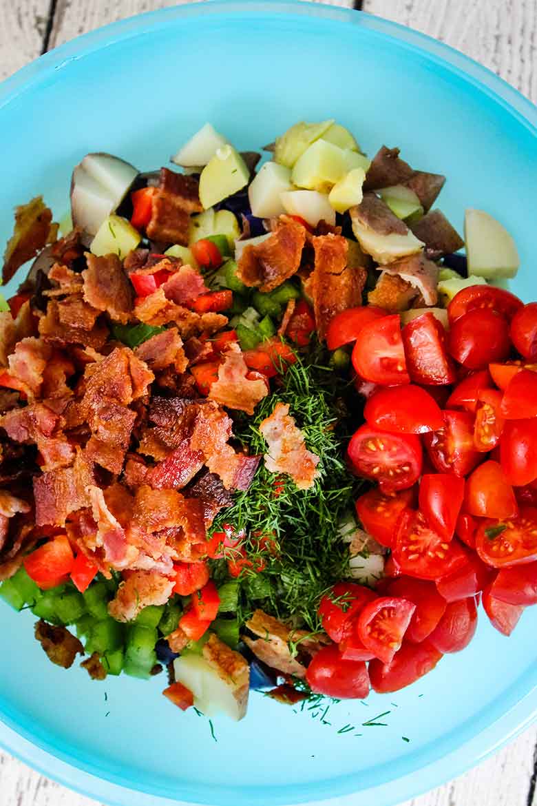 Potato salad ingredients in a blue bowl without the dressing.