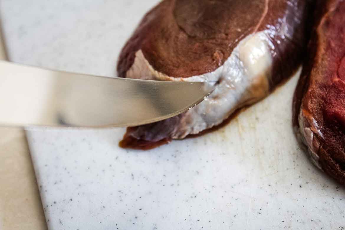 Removing the silverskin from the venison tenderloin.