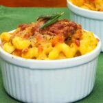 Upclose image of Butternut Squash Pasta Bake in a white ramekin topped with crispy breadcrumbs and fried sage.