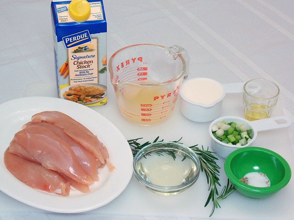 raw chicken tenders on a white plate with ingredients for recipe