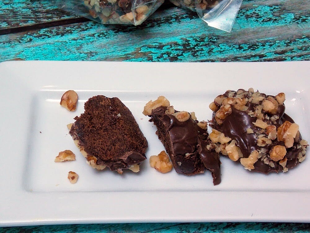 A plate with chocolate coated brownies that have been cut in half.