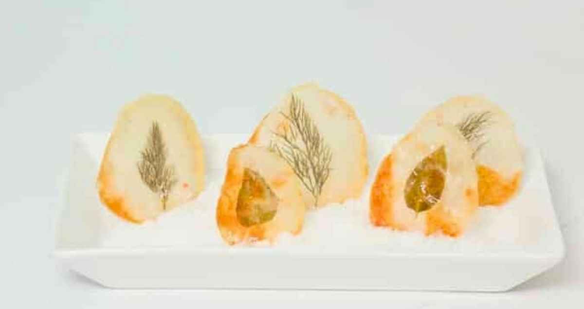 Window Pane Potato Chips standing up in a serving tray with rock salt.