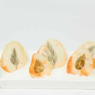 Window Pane Potato Chips standing up in a serving tray with rock salt.