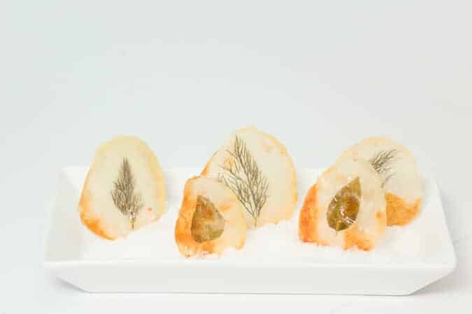 Window Pane Potato Chips standing up in a serving tray with rock salt.