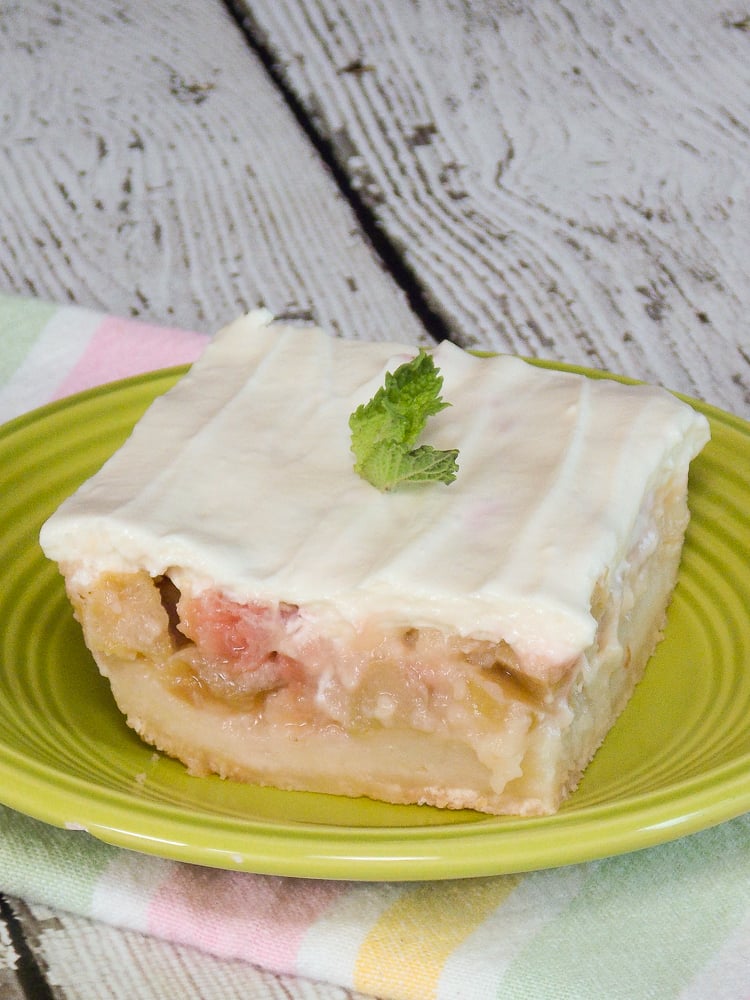 Rhubarb Custard Bars on a lime green plate topped with a green mint sprig.