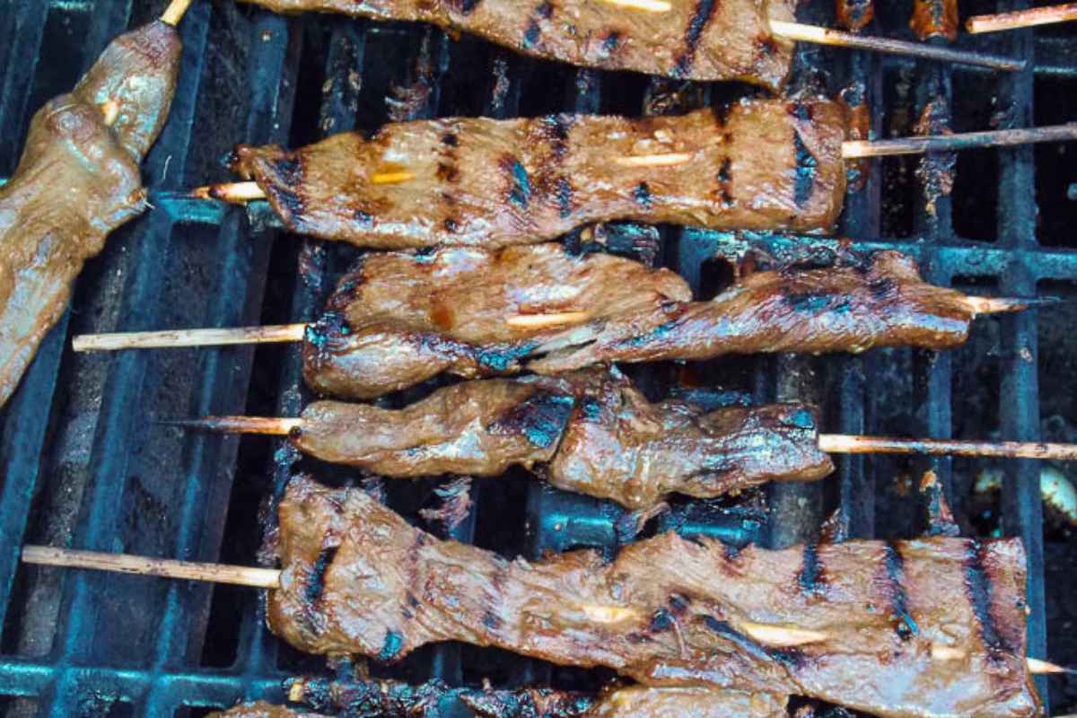Skewered venison satay on the grill.