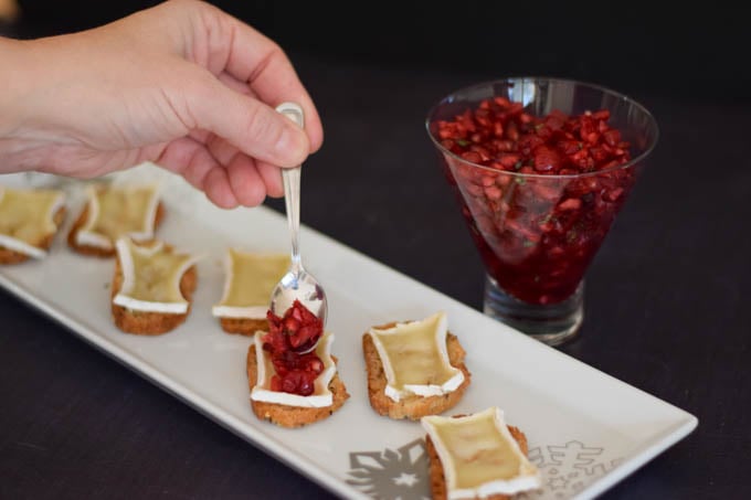 adding the cranberry relish on top of the brie toasts