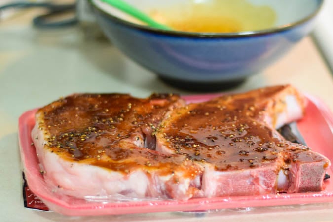 seasoned bone-in pork chops prior to cooking.