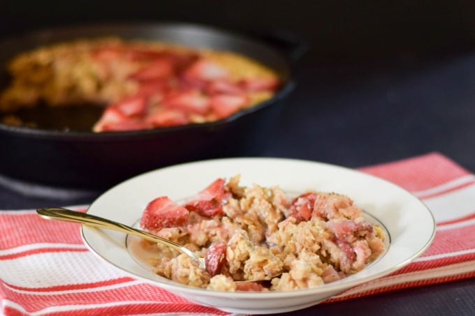 One serving of Strawberry Baked Oatmeal in a cream bowl with gold rim.