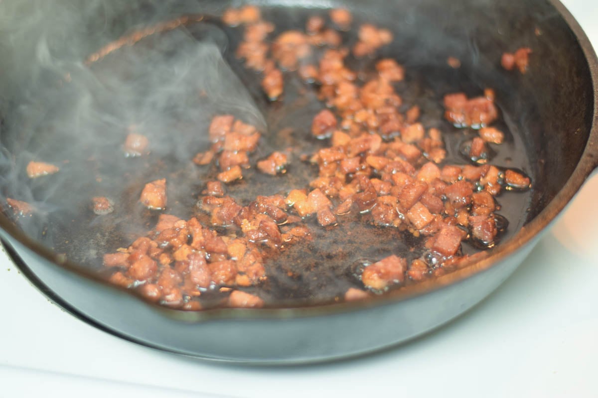 Pancetta cooking in a skillet.