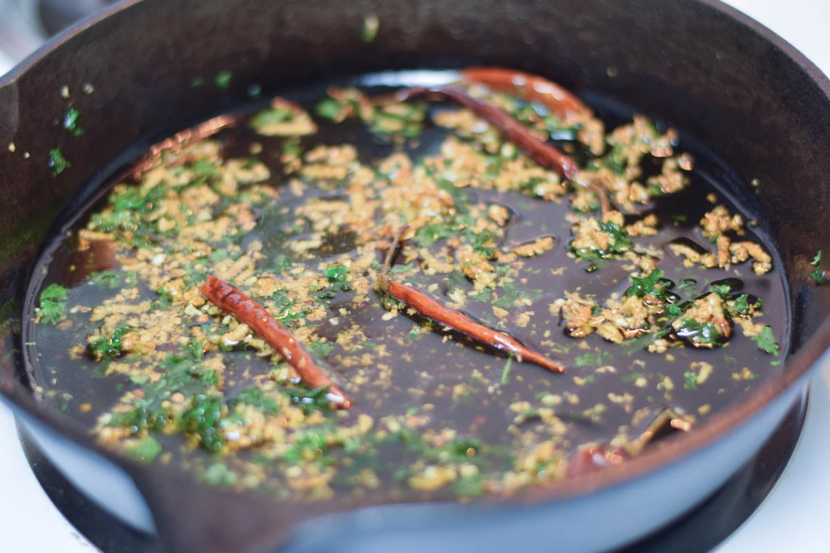 Garlic, dried red peppers and fresh parsley in the hot oil.