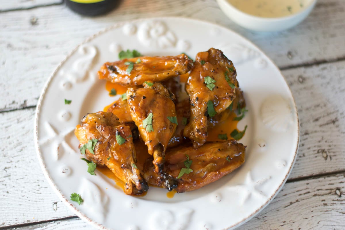 A pile of crispy chicken wings on a white plate.