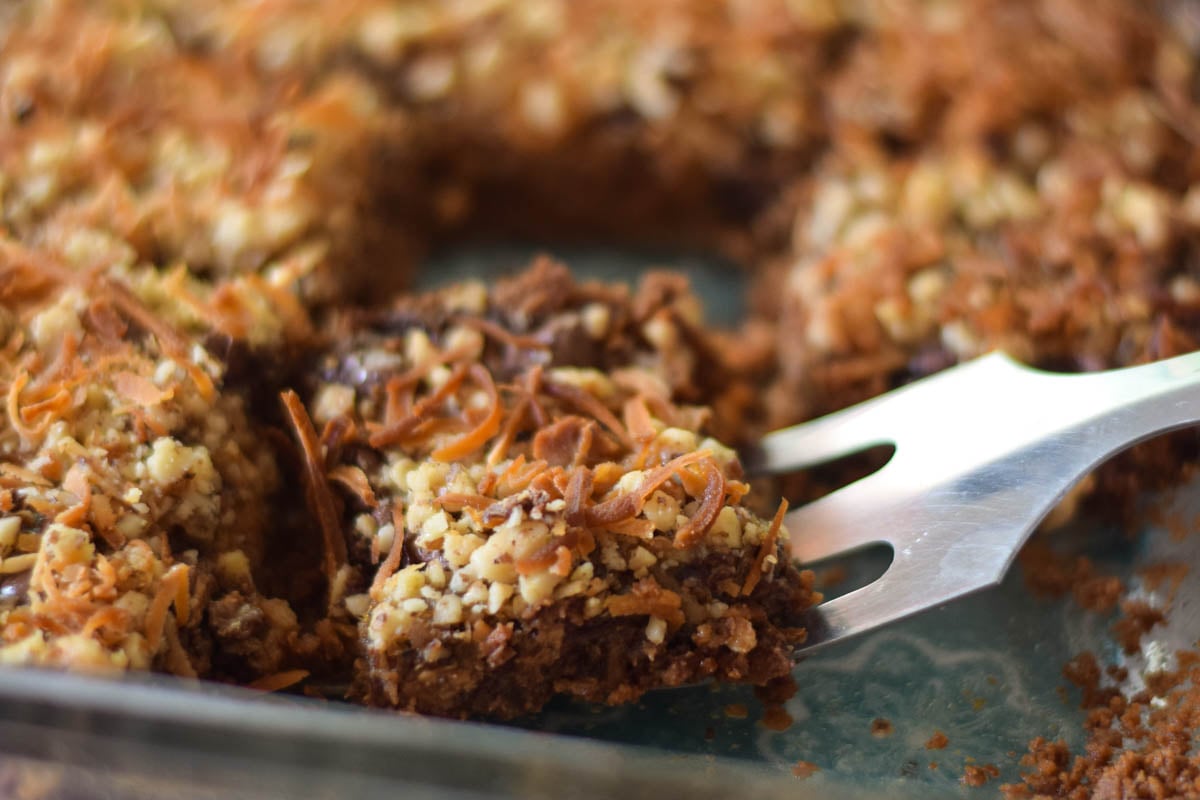 Removing a Chewy Peanut Butter Layer Bar with a spatula from the baking dish.