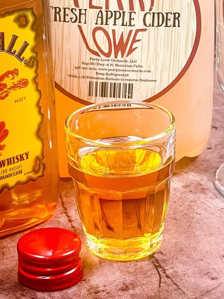 Close up image of a shot glass filled with whisky.
