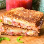 Upclose image of bacon grilled cheese sandwich with rhubarb sauce and jalapeno.