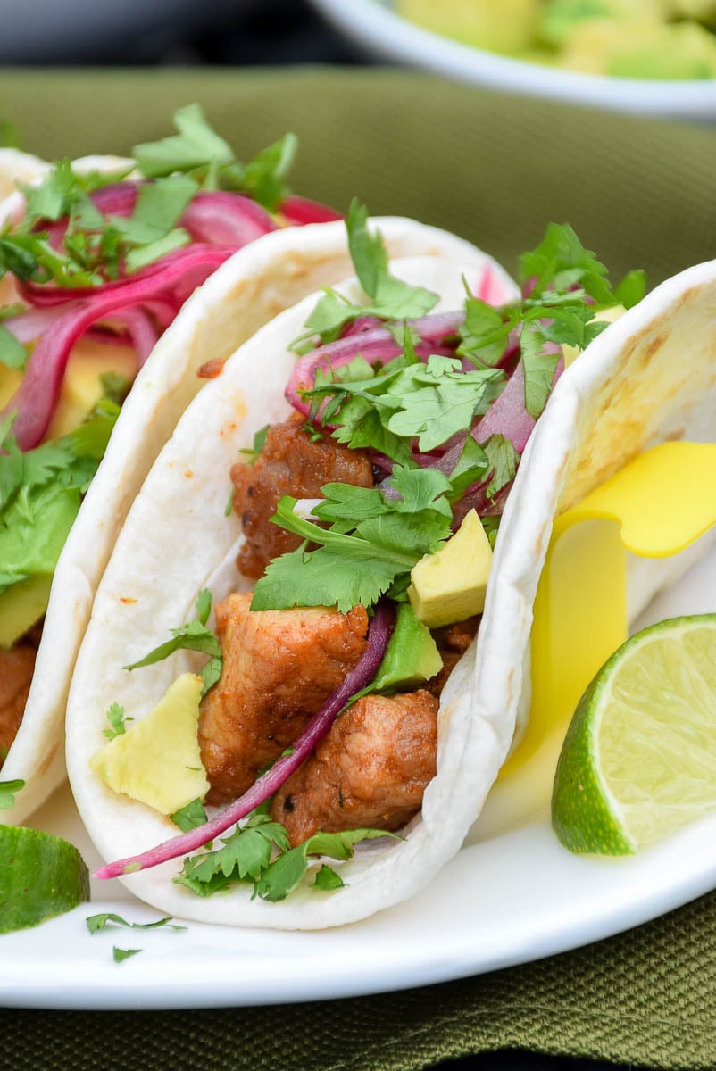 Pork Street Tacos topped with pickled onions, avocado, and cilantro.