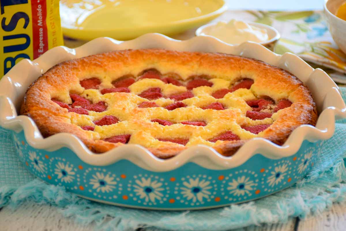 A blue flowered dish with a baked coffee cake studded with Raspberries.