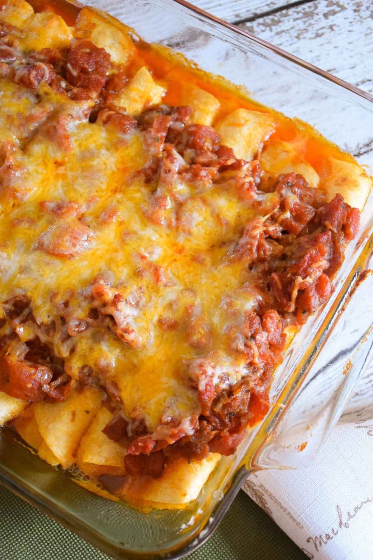 Overhead view of baked vegetarian cheese enchiladas in a casserole dish.