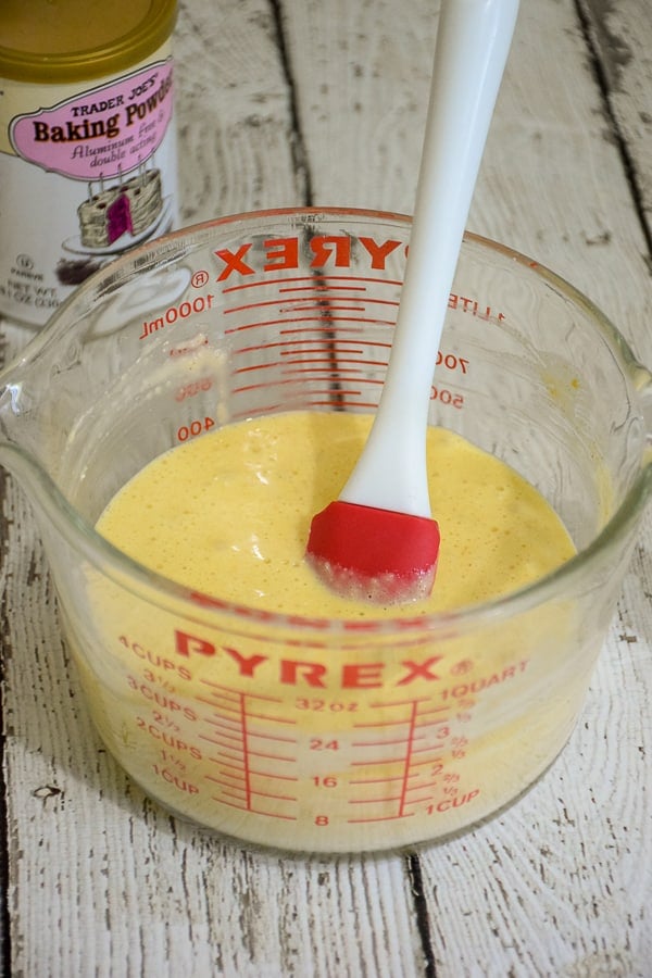 Pancake batter made with almond flour in a large measuring cup with a rubber scraper.