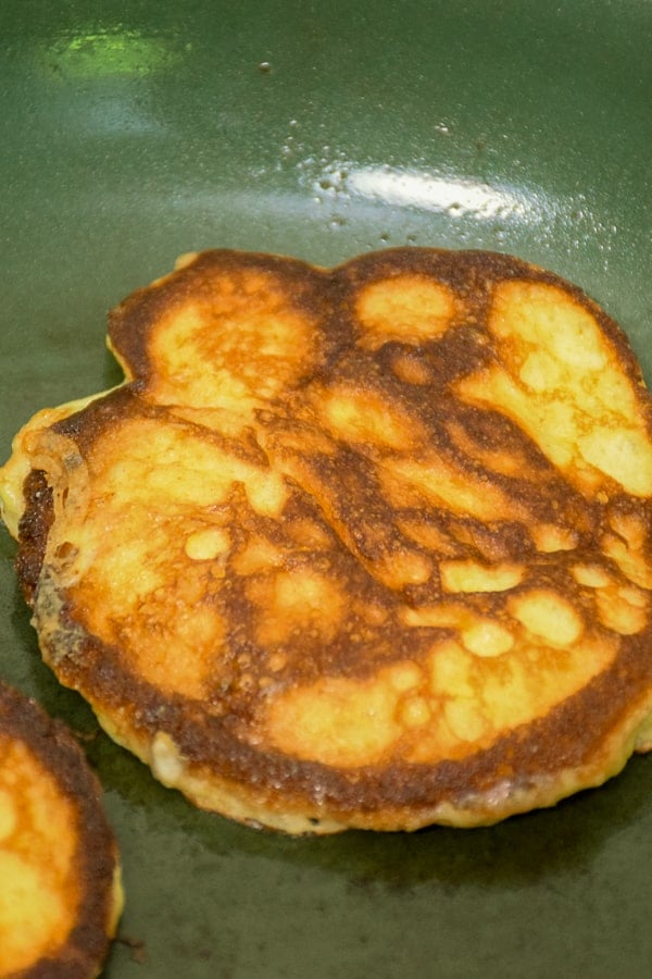 Pancakes cooking in a skillet.