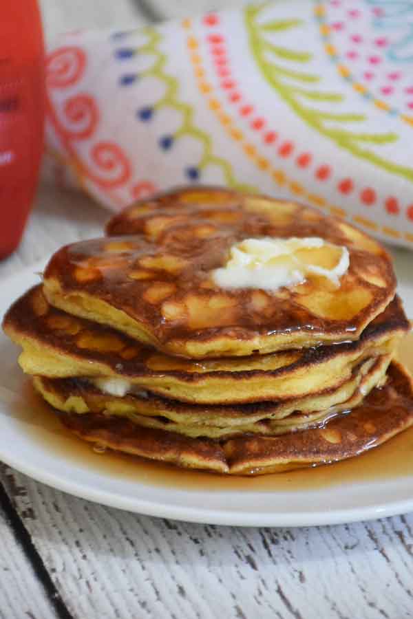 A stack of almond flour protein pancakes made with almond flour covered with butter and syrup.