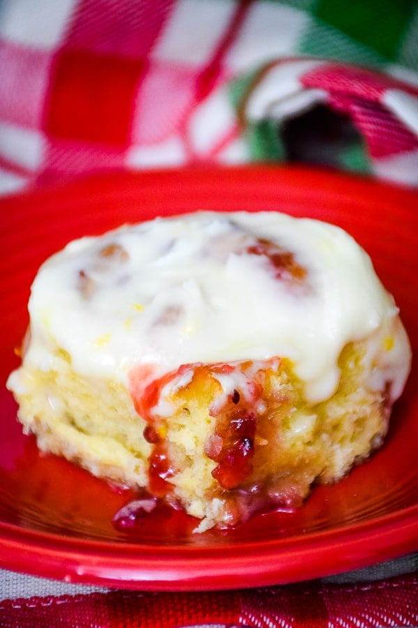 One cranberry orange sweet roll on a white plate.