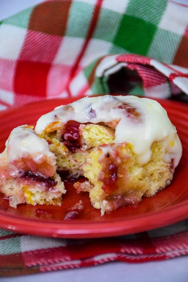 Cranberry Orange Sweet Roll on a red plate with a piece cut out.